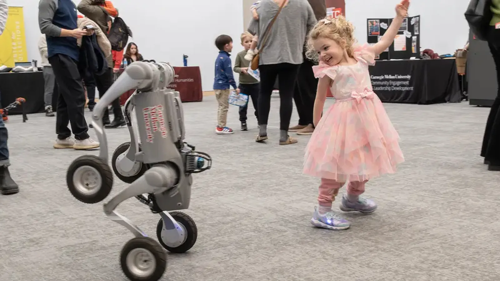 A little girl dances with a robot at CMU's new RIC building.